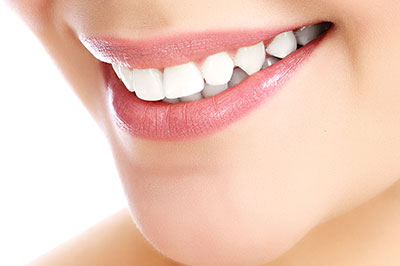 The image shows a close-up of a person s face, focusing on their teeth and lips, with a clear emphasis on dental hygiene and cosmetic dentistry services.